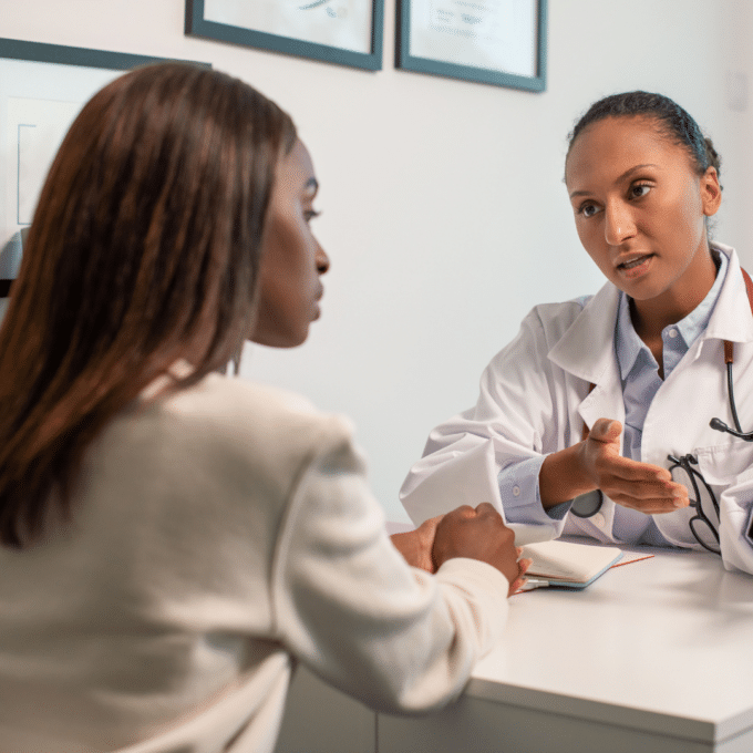 A GP explaining iron infusion treatment options to a patient during a consultation